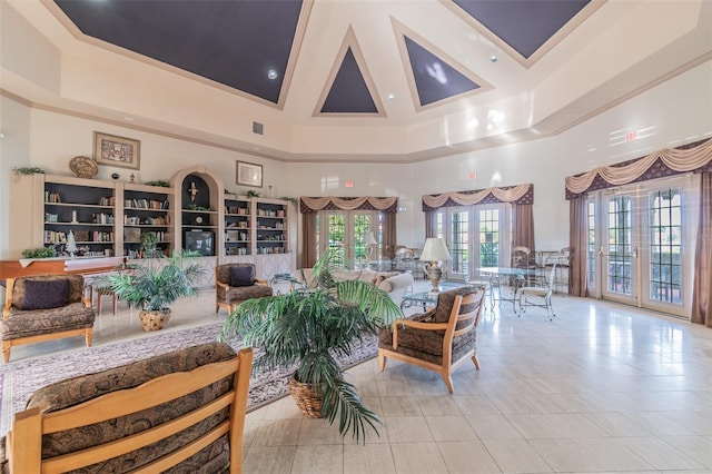 living room featuring a high ceiling, french doors, light tile floors, and a raised ceiling