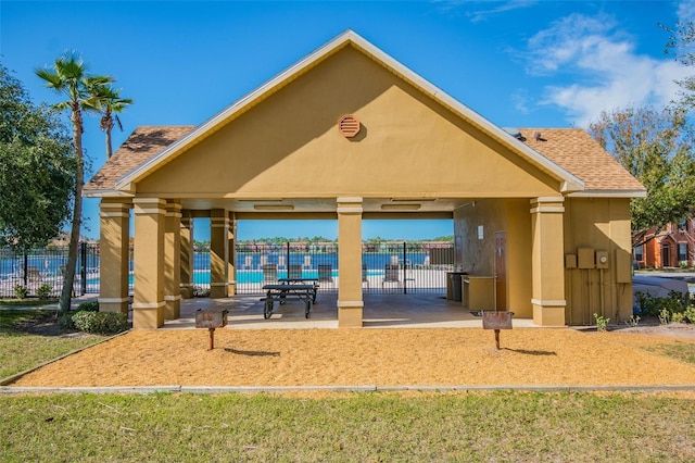 view of property's community featuring a lawn and a patio area