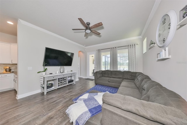 living room with ceiling fan, dark hardwood / wood-style floors, and ornamental molding