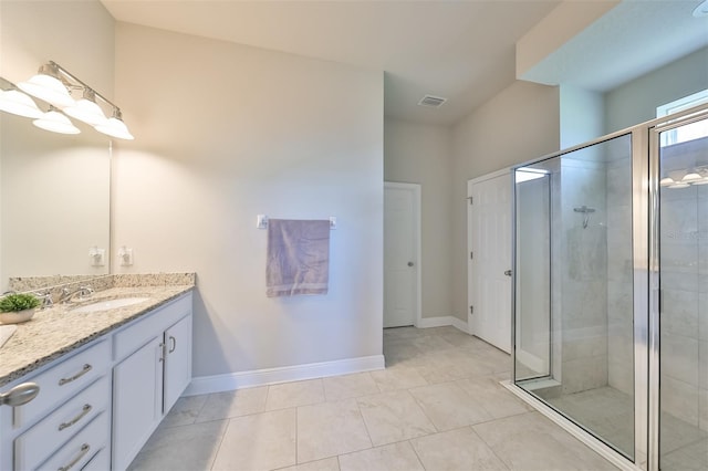 bathroom with tile patterned flooring, vanity, and a shower with shower door