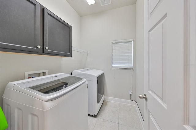 washroom featuring light tile patterned flooring, cabinets, and independent washer and dryer