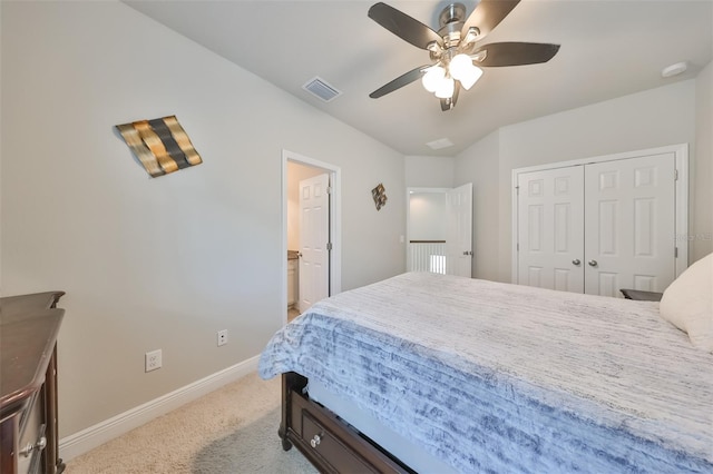 bedroom featuring light carpet, a closet, ensuite bath, and ceiling fan