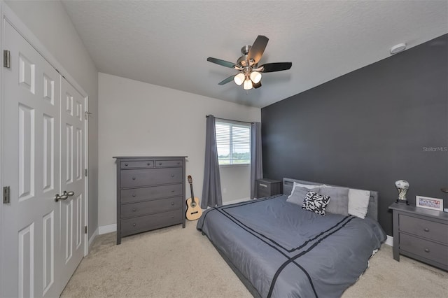 bedroom featuring ceiling fan, a closet, and a textured ceiling