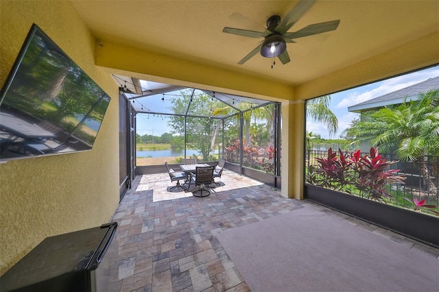 unfurnished sunroom with ceiling fan