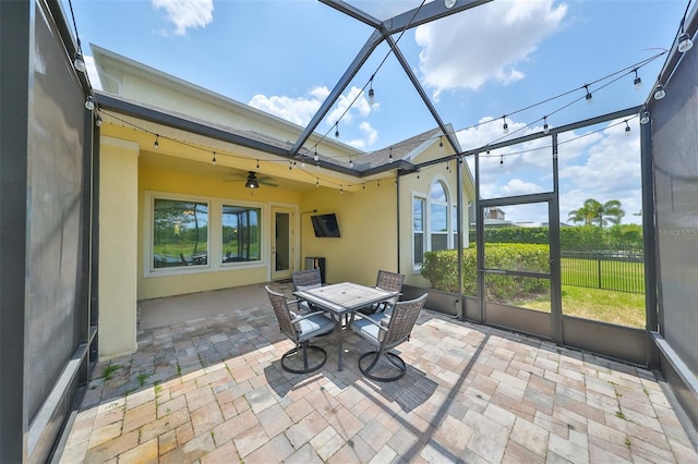 unfurnished sunroom featuring ceiling fan