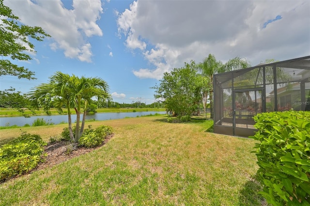 view of yard featuring a lanai and a water view