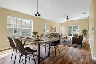 dining area featuring ceiling fan, dark wood-type flooring, and vaulted ceiling