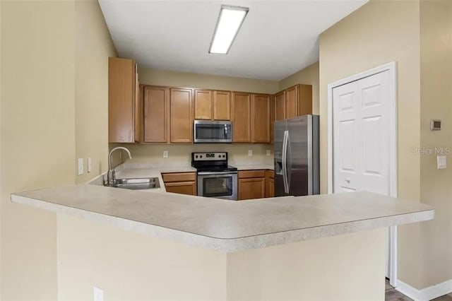 kitchen featuring kitchen peninsula, appliances with stainless steel finishes, and sink