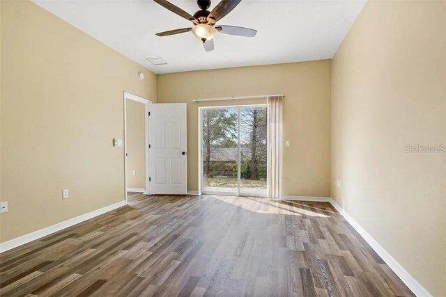 empty room featuring wood finished floors, baseboards, and ceiling fan