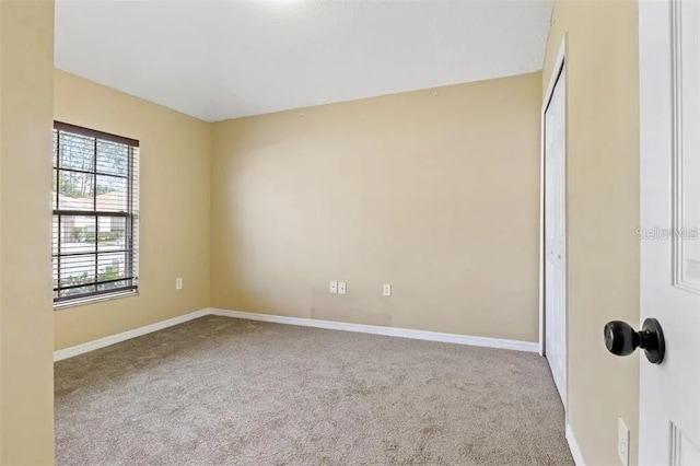 unfurnished bedroom featuring carpet flooring, baseboards, and a closet