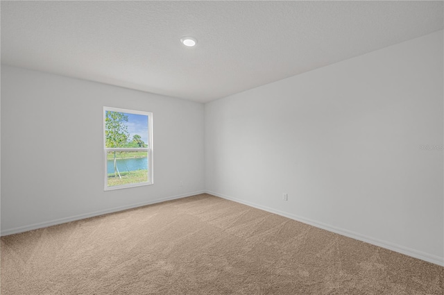 empty room with light carpet, recessed lighting, and baseboards