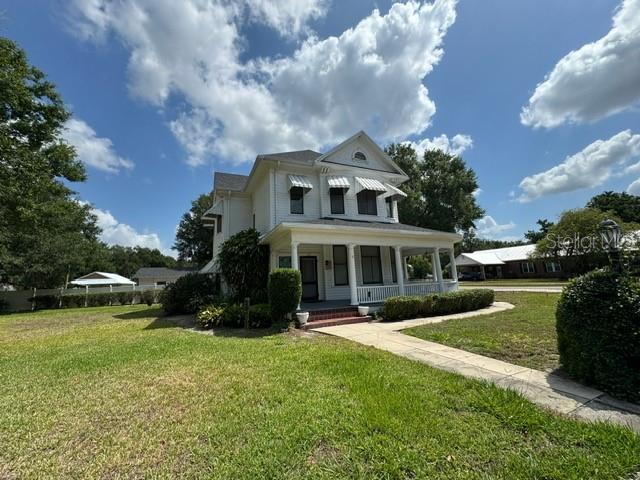 view of front facade featuring a front yard and covered porch