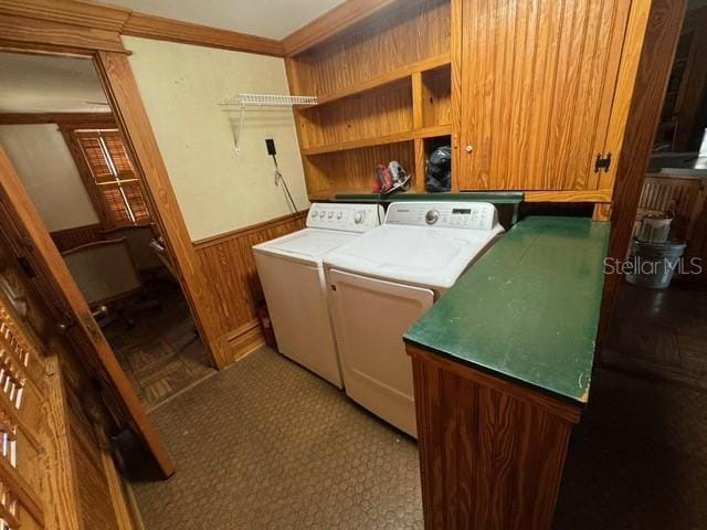 laundry room with independent washer and dryer and wood walls