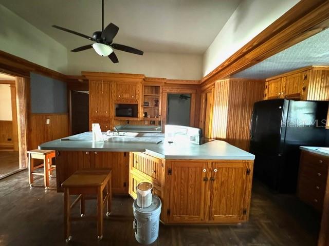 kitchen featuring black appliances, ceiling fan, and a kitchen island