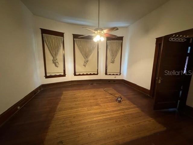 interior space with ceiling fan and dark hardwood / wood-style floors