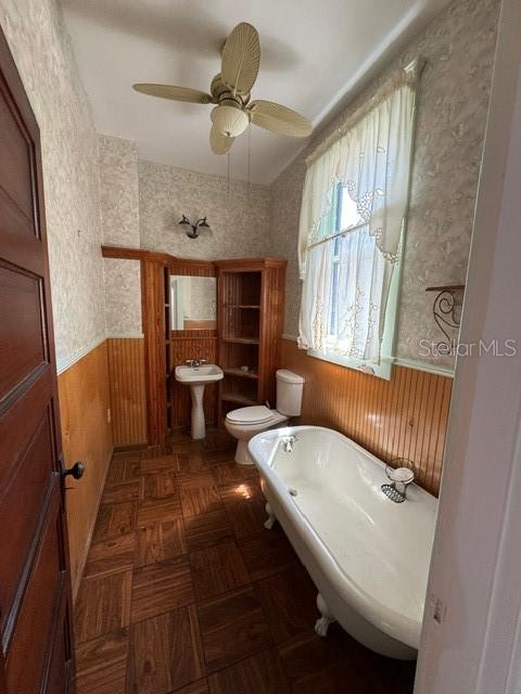 bathroom with ceiling fan and toilet