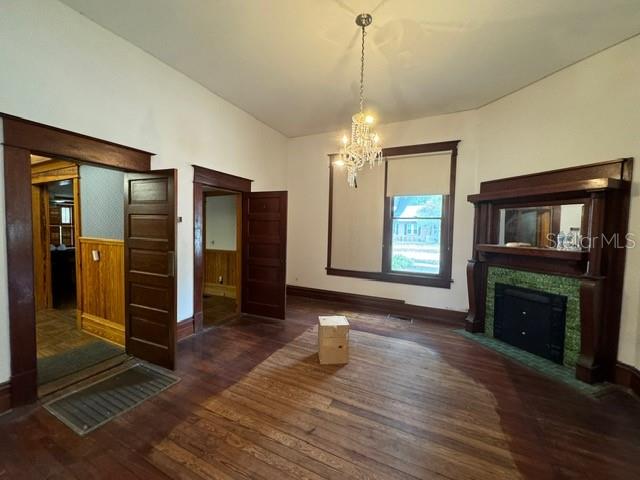 unfurnished dining area with an inviting chandelier and dark wood-type flooring