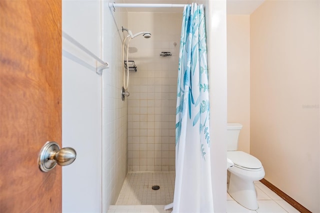 bathroom featuring tile patterned floors, a stall shower, toilet, and baseboards