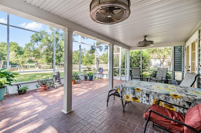 view of patio / terrace with outdoor dining space, a lanai, and a ceiling fan