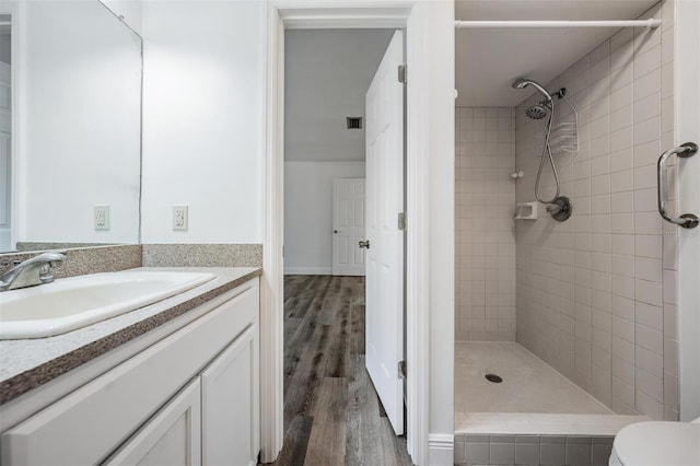 full bathroom with visible vents, toilet, a stall shower, wood finished floors, and vanity