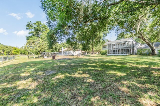 view of yard with fence and a sunroom