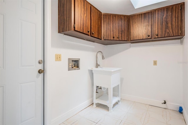 washroom featuring baseboards, cabinet space, washer hookup, and a skylight