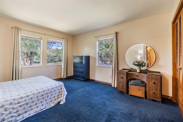 bedroom with dark carpet and baseboards