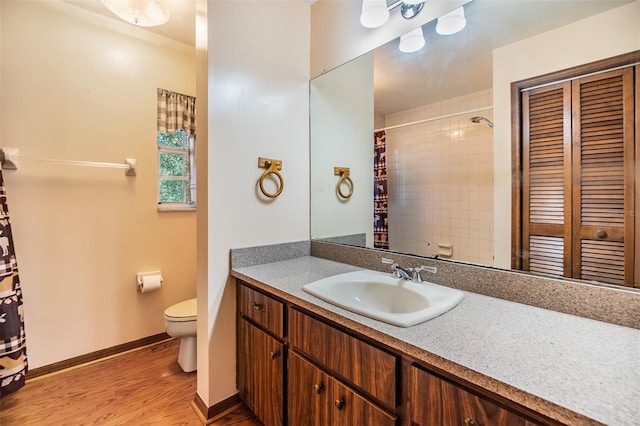 bathroom featuring curtained shower, baseboards, toilet, wood finished floors, and vanity