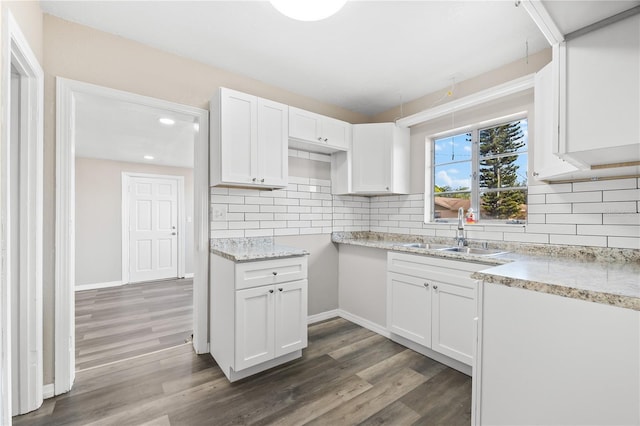 kitchen with backsplash, white cabinetry, sink, and dark hardwood / wood-style floors