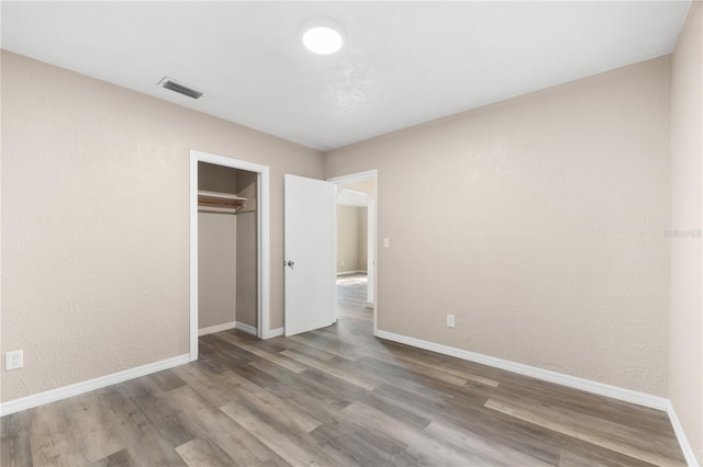 unfurnished bedroom with wood-type flooring and a closet