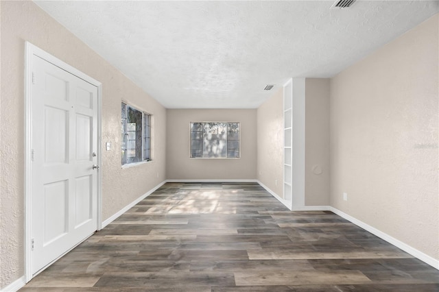 foyer entrance featuring a textured ceiling and dark hardwood / wood-style floors