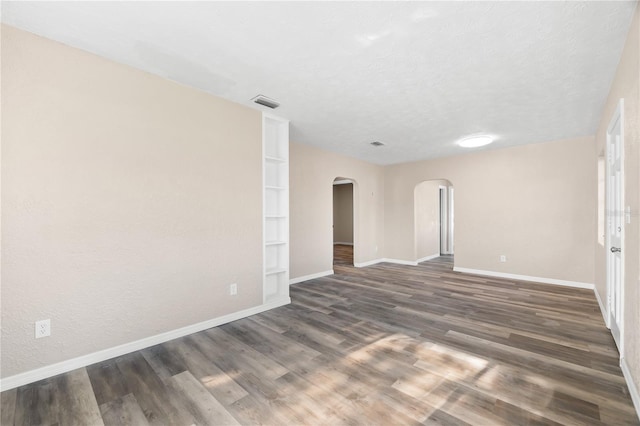 spare room featuring a textured ceiling and dark wood-type flooring