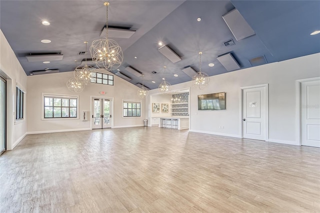 unfurnished living room with high vaulted ceiling and light hardwood / wood-style flooring