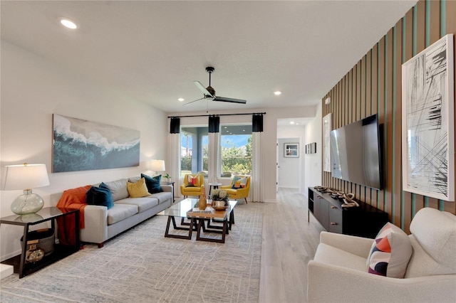 living room with ceiling fan and light hardwood / wood-style flooring