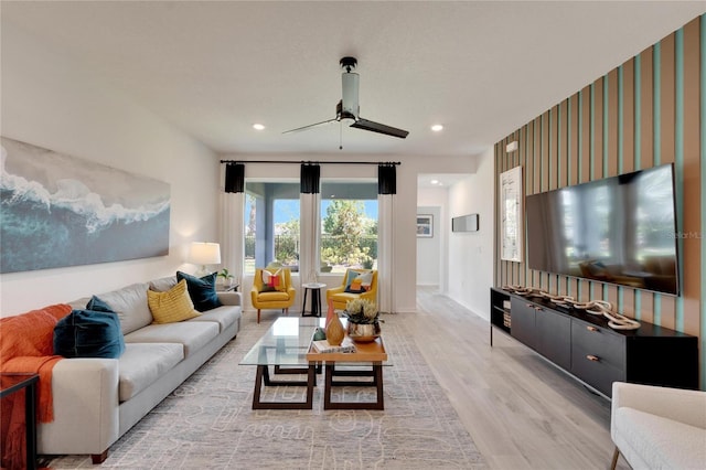 living room featuring light hardwood / wood-style flooring and ceiling fan