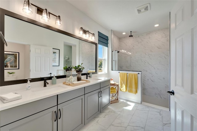 bathroom with a tile shower and vanity