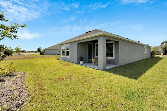 rear view of property with a yard and a patio area