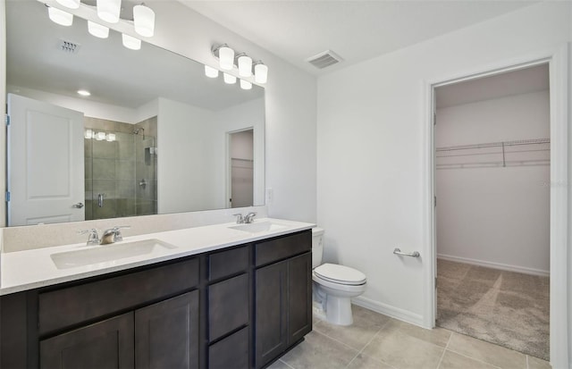 bathroom with toilet, vanity, tile patterned floors, and a shower with door