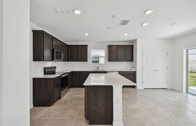 kitchen featuring a center island, decorative backsplash, a healthy amount of sunlight, and appliances with stainless steel finishes