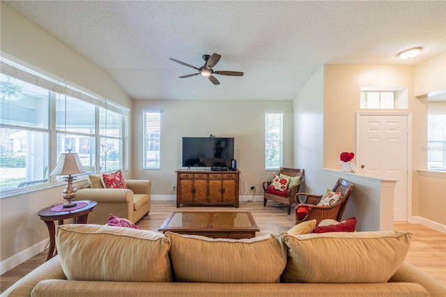 living room featuring a textured ceiling, a wealth of natural light, and light hardwood / wood-style flooring