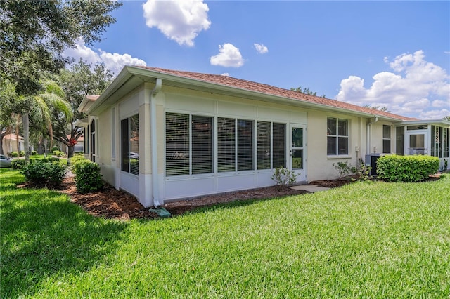 back of property with a yard and central air condition unit