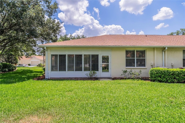 rear view of property featuring a lawn