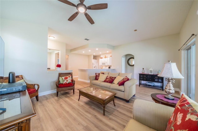 living room with ceiling fan and light hardwood / wood-style flooring