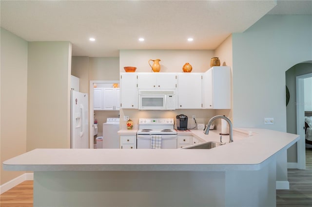 kitchen with light hardwood / wood-style floors, white appliances, sink, and washer / clothes dryer