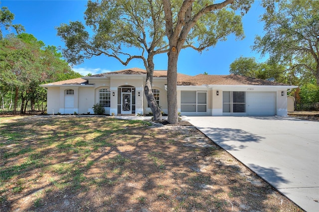 view of front facade with driveway, an attached garage, and stucco siding