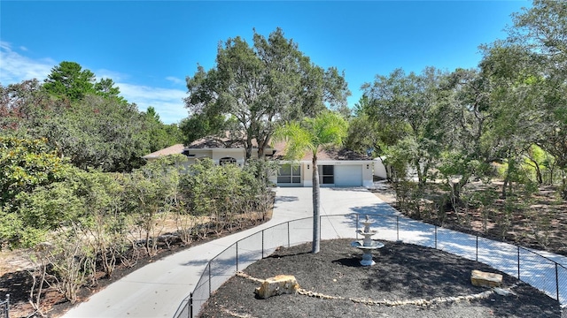 mediterranean / spanish-style home featuring a garage, fence, and driveway