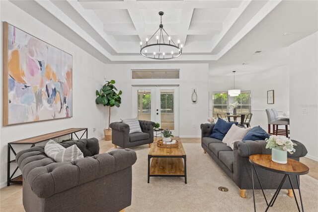 living room with french doors, beamed ceiling, an inviting chandelier, coffered ceiling, and a towering ceiling