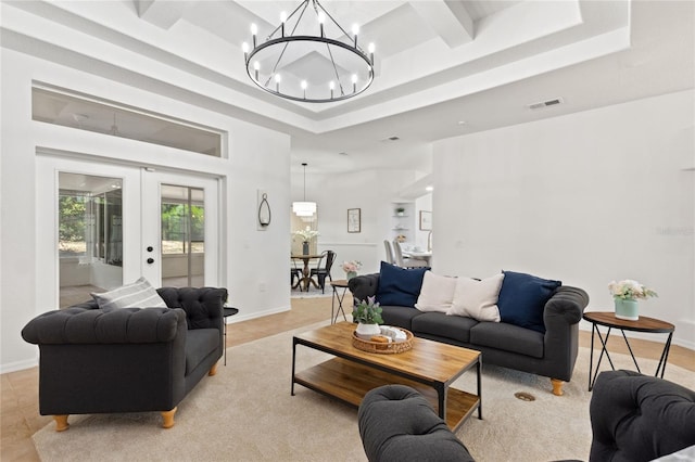 living room with a tray ceiling, a notable chandelier, french doors, and light tile floors