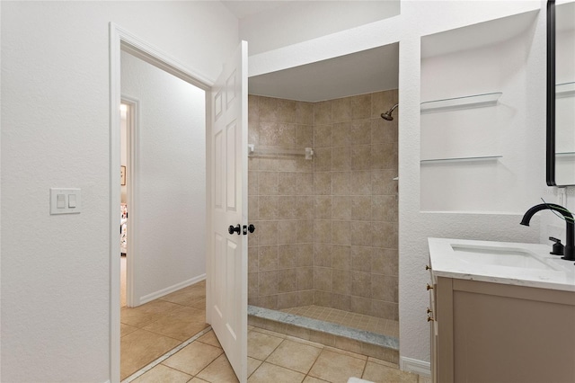 bathroom featuring a tile shower, vanity, and tile floors