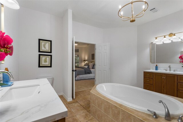 bathroom with a relaxing tiled bath, tile flooring, and vanity